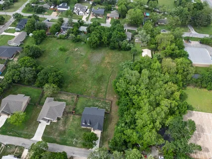 an aerial view of residential house with outdoor space and trees all around