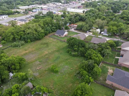 an aerial view of residential houses with outdoor space and trees