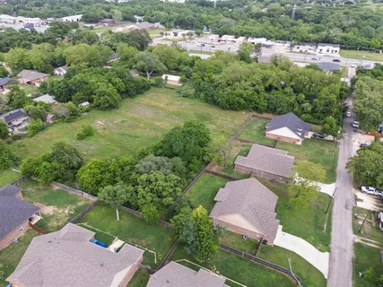 an aerial view of residential houses with outdoor space and street view