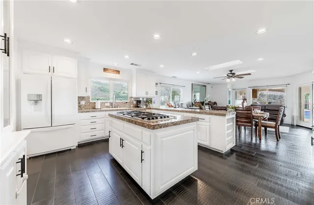 a kitchen with granite countertop white cabinets and white appliances