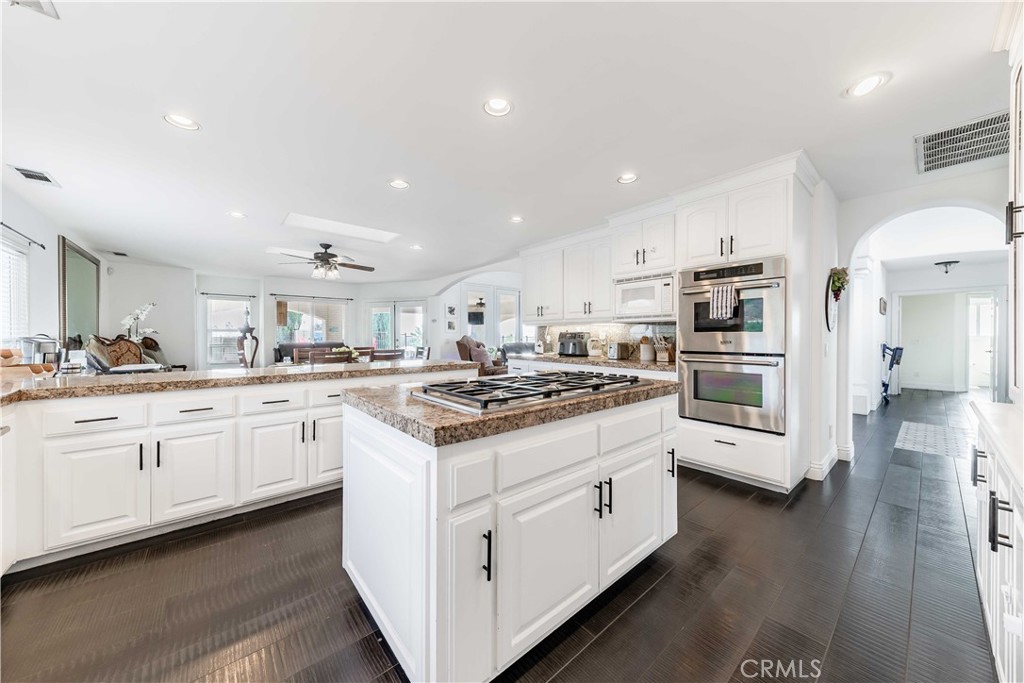 20491 Carancho Road Temecula, CA 92590 - Photo 13 of 64 a kitchen with stainless steel appliances kitchen island granite countertop a stove a sink and a refrigerator