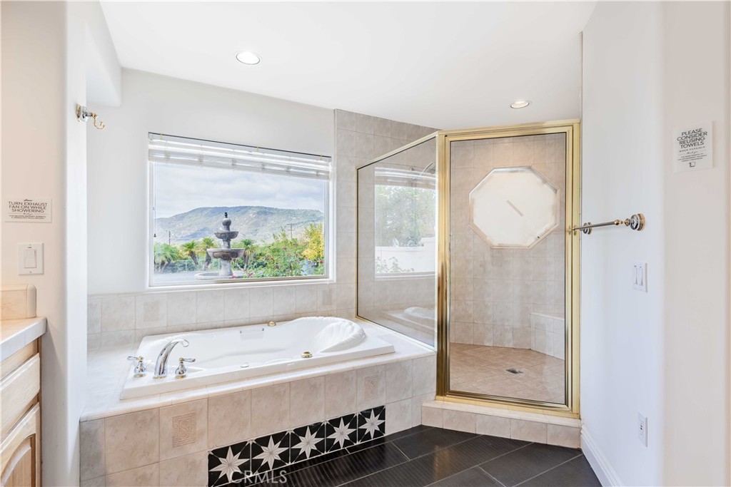 20491 Carancho Road Temecula, CA 92590 - Photo 24 of 64 a bathroom with a tub a sink and glass door shower