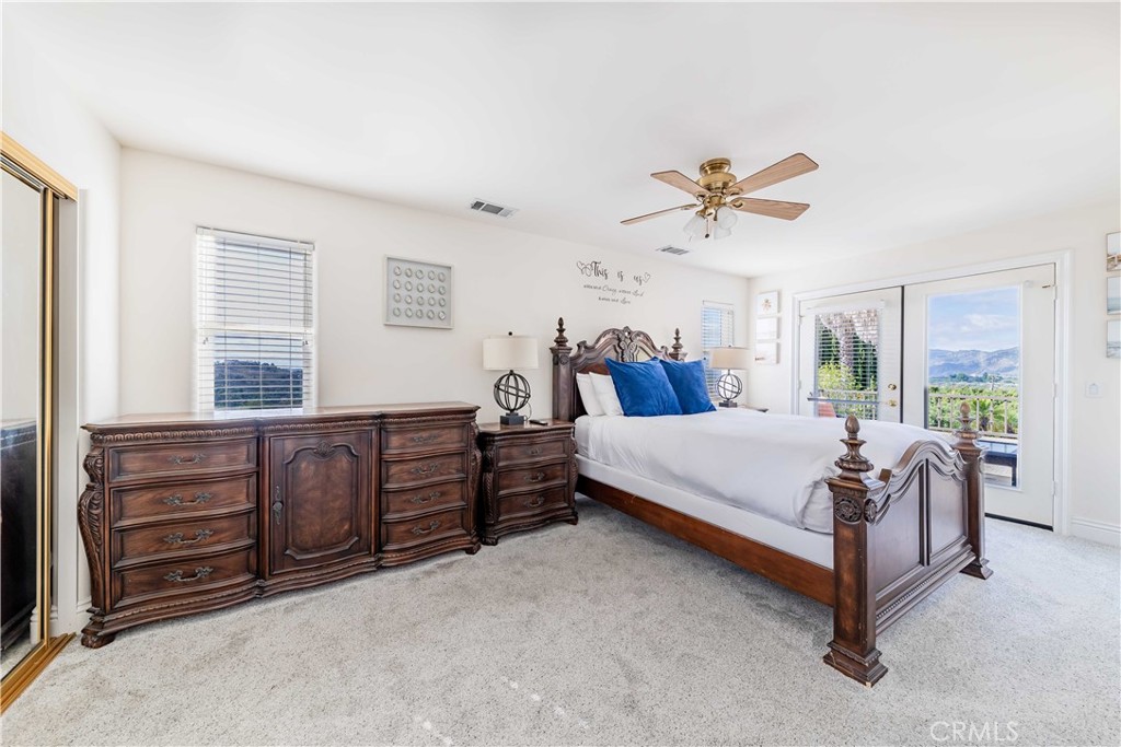 20491 Carancho Road Temecula, CA 92590 - Photo 27 of 64 a bed room with a bed and a chandelier