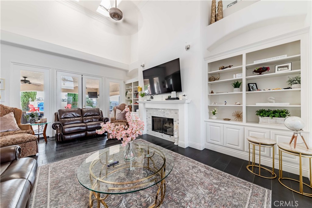 20491 Carancho Road Temecula, CA 92590 - Photo 8 of 64 a living room with furniture a fireplace a flat screen tv and a window