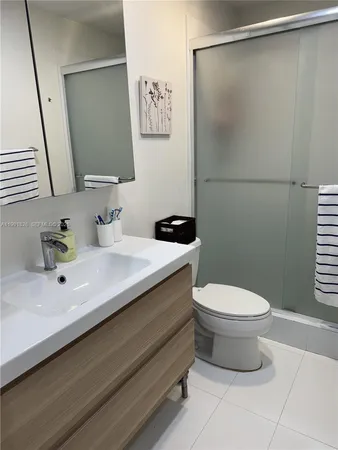 a bathroom with a sink a toilet a mirror and shower