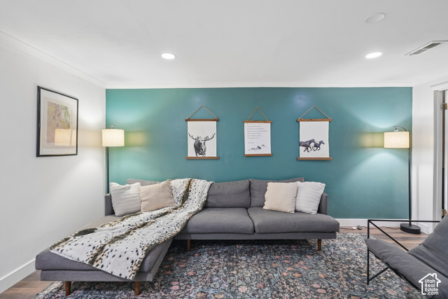 7391 Ramanee Drive Midvale, UT 84047 - Photo 23 of 45 Recessed ceiling lighting, crown molding, wood-finish flooring, and a vibrant accent wall