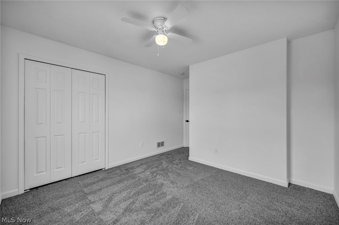 3633 Pennington Road Cleveland, OH 44120 - Photo 25 of 34 Unfurnished bedroom with dark colored carpet, ceiling fan, and a closet