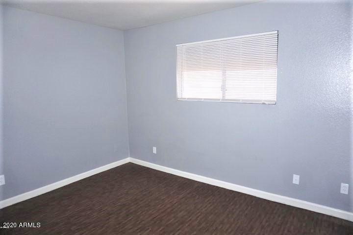 18202 North Cave Creek Road, Unit 231 Phoenix, AZ 85032 - Photo 13 of 18 a view of an empty room with wooden floor and a window