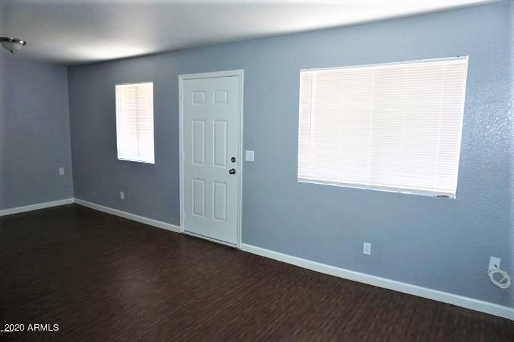 18202 North Cave Creek Road, Unit 231 Phoenix, AZ 85032 - Photo 3 of 18 an empty room with wooden floor and windows