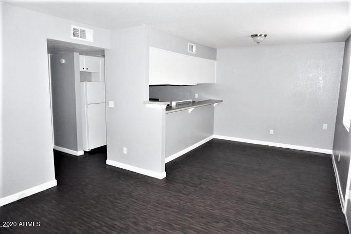 18202 North Cave Creek Road, Unit 231 Phoenix, AZ 85032 - Photo 4 of 18 a view of an empty room with wooden floor and a window