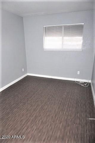 18202 North Cave Creek Road, Unit 231 Phoenix, AZ 85032 - Photo 8 of 18 a view of an empty room with wooden floor and a window