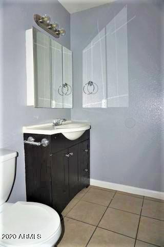 18202 North Cave Creek Road, Unit 231 Phoenix, AZ 85032 - Photo 10 of 18 a bathroom with a sink a toilet a mirror and vanity