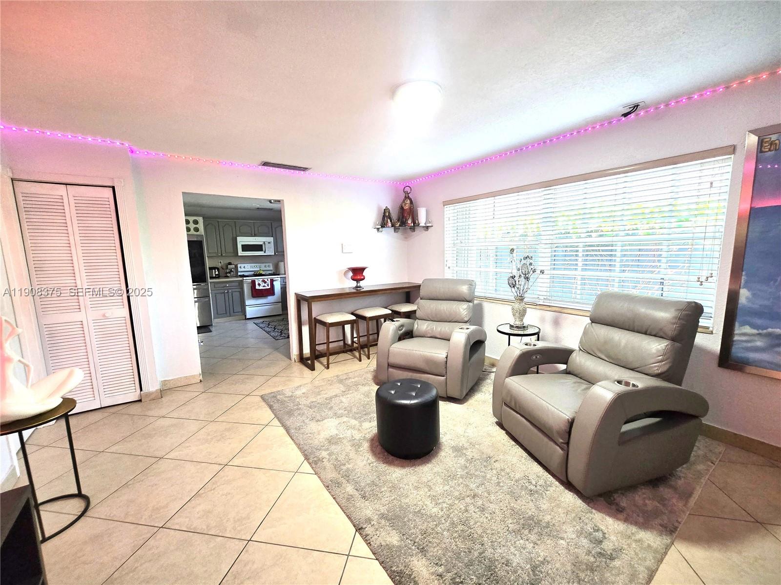 11152 Southwest 7th Street Sweetwater, FL 33174 - Photo 15 of 53 a living room with furniture a flat screen tv and a large window