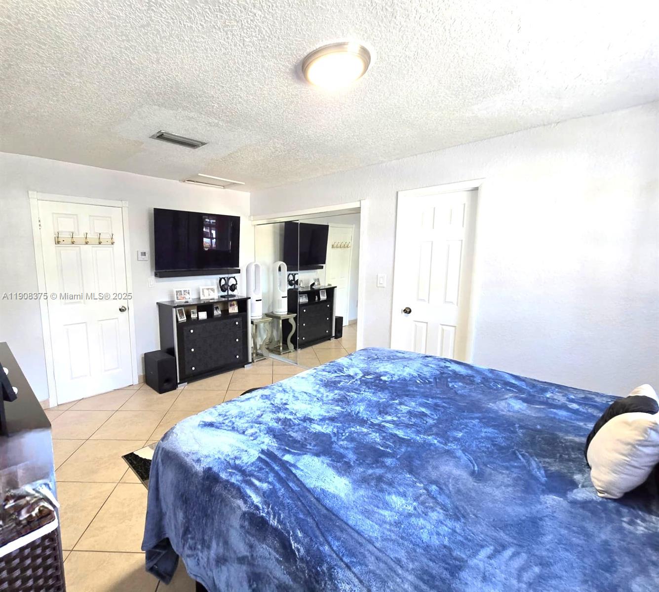 11152 Southwest 7th Street Sweetwater, FL 33174 - Photo 21 of 52 a large bedroom with a bed and a flat screen tv