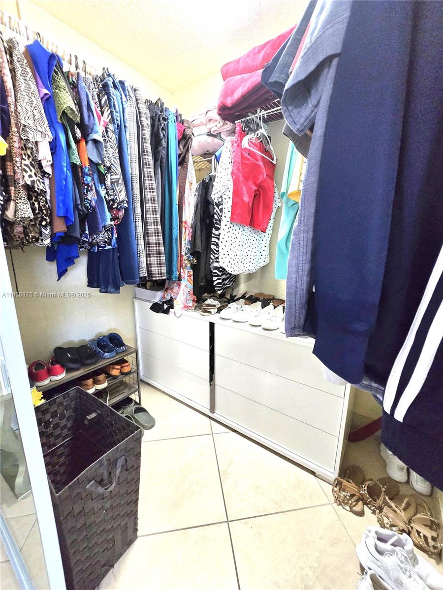 11152 Southwest 7th Street Sweetwater, FL 33174 - Photo 23 of 52 a view of walk in closet with clothes and shoes