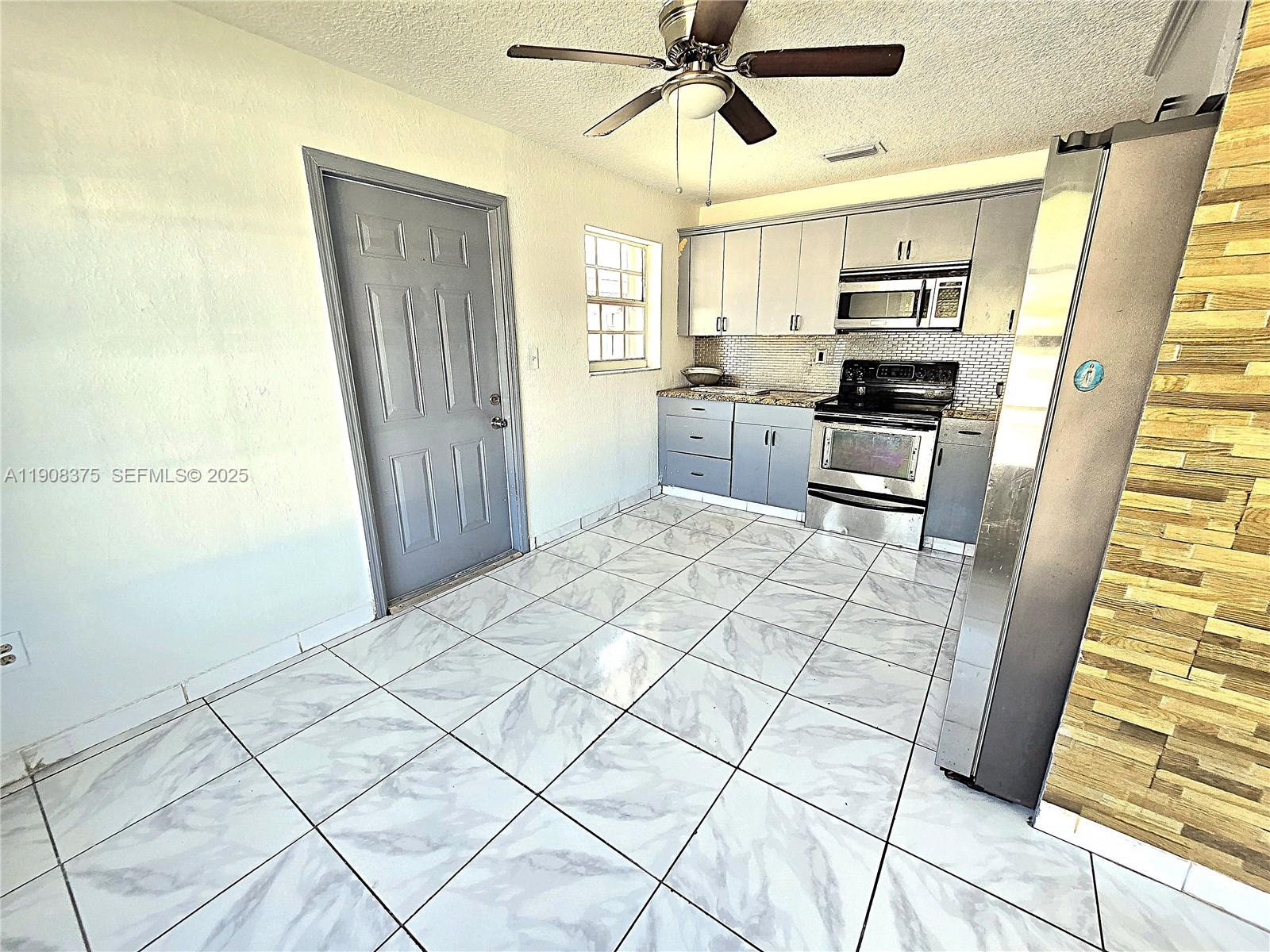 11152 Southwest 7th Street Sweetwater, FL 33174 - Photo 43 of 53 a kitchen with stainless steel appliances a refrigerator and microwave