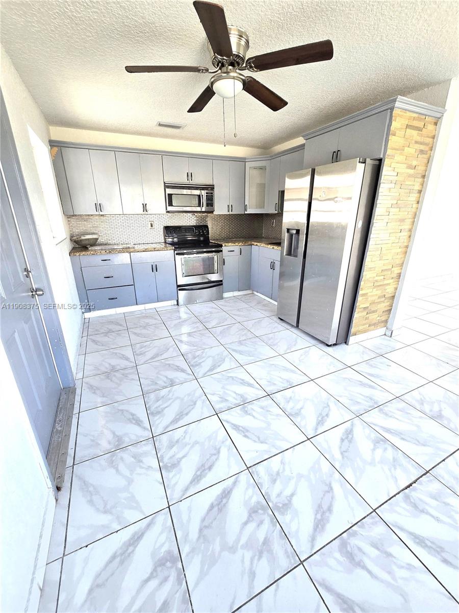 11152 Southwest 7th Street Sweetwater, FL 33174 - Photo 44 of 53 a large kitchen with cabinets and stainless steel appliances