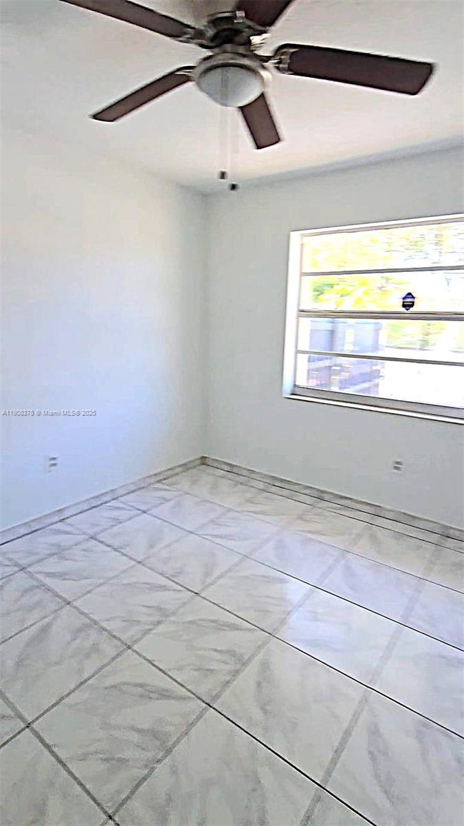 11152 Southwest 7th Street Sweetwater, FL 33174 - Photo 47 of 52 a view of a room with a window and a ceiling fan