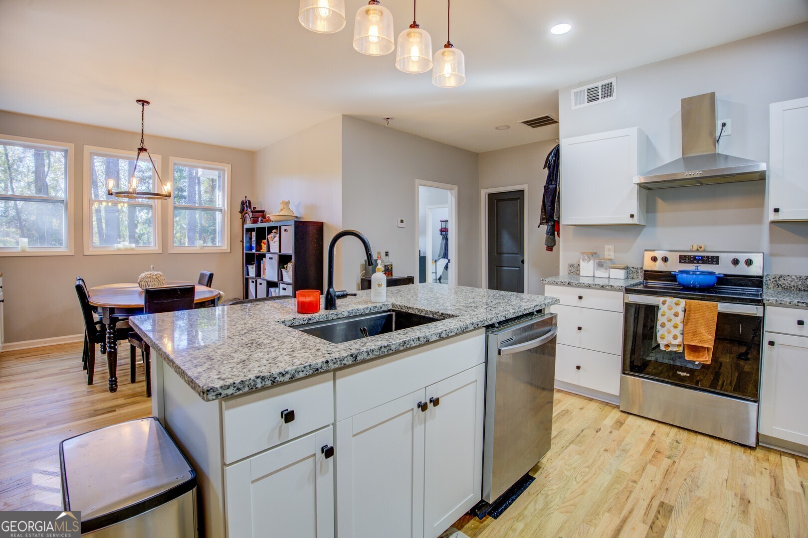 13 Goldfinch Circle Monticello, GA 31064 - Photo 23 of 44 a kitchen with stainless steel appliances granite countertop a stove oven a sink dishwasher and white cabinets with wooden floor