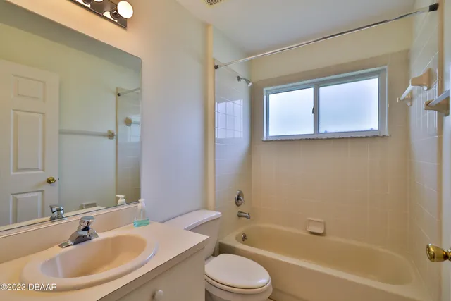 an empty room with a window and a ceiling fan