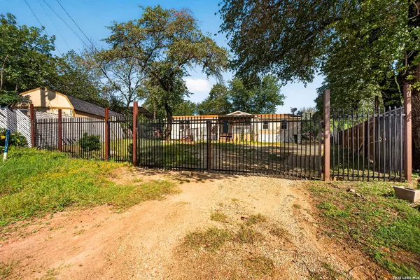 a view of a house with a large tree and wooden fence