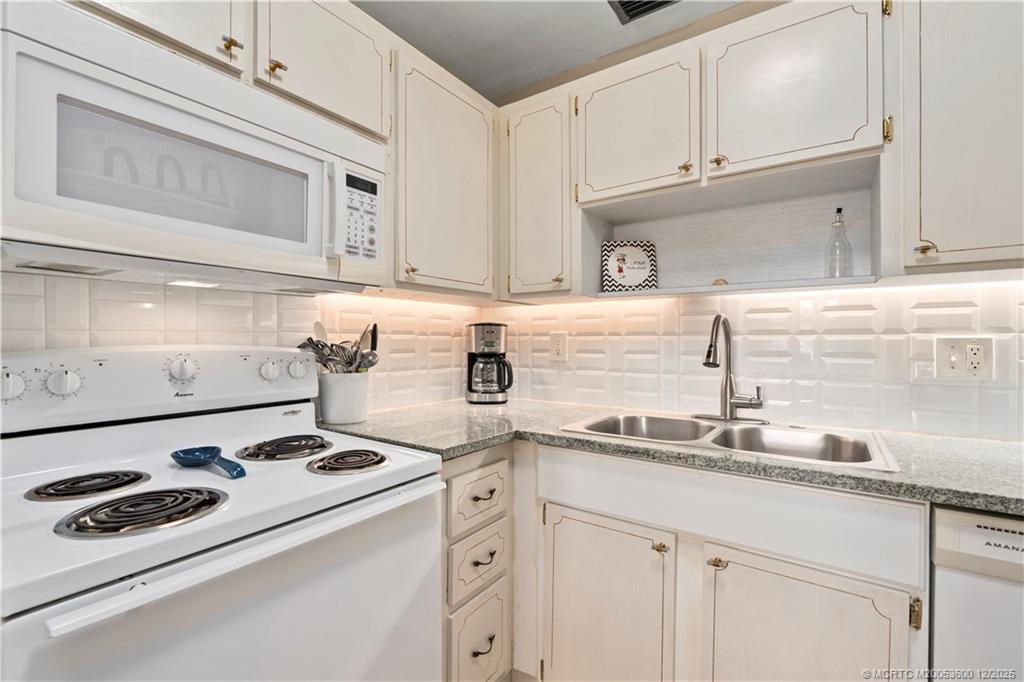 2600 Southeast Ocean Boulevard, Unit EE12 Stuart, FL 34996 - Photo 8 of 43 a kitchen with kitchen island a sink a stove and cabinets