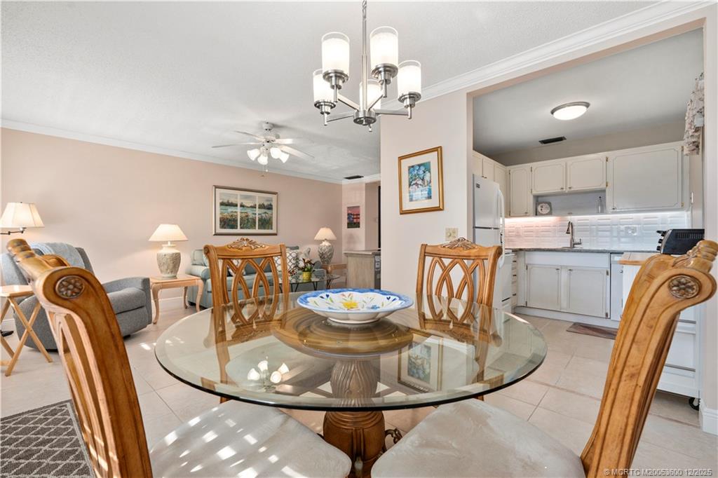 2600 Southeast Ocean Boulevard, Unit EE12 Stuart, FL 34996 - Photo 10 of 43 a dining room with wooden floor a chandelier a wooden table and chairs
