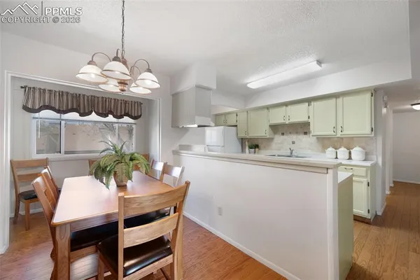 a kitchen with stainless steel appliances kitchen island granite countertop a table and chairs in it