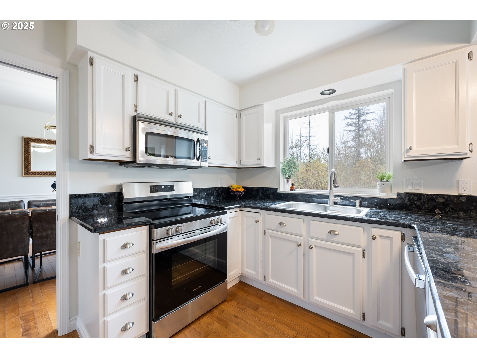 16033 Northwest Ridgetop Lane Beaverton, OR 97006 - Photo 6 of 42 a kitchen with stainless steel appliances granite countertop a stove a sink and white cabinets