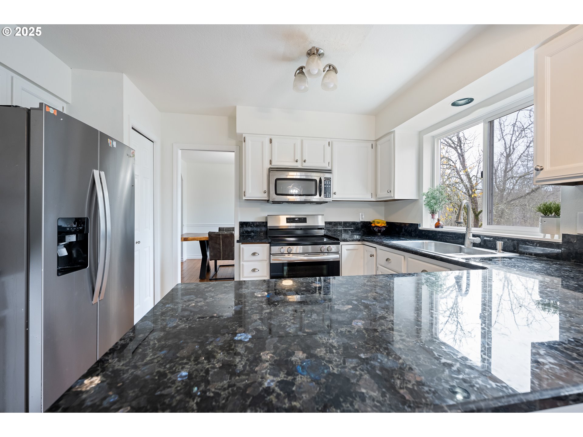 16033 Northwest Ridgetop Lane Beaverton, OR 97006 - Photo 7 of 42 a kitchen with granite countertop a refrigerator and a stove top oven