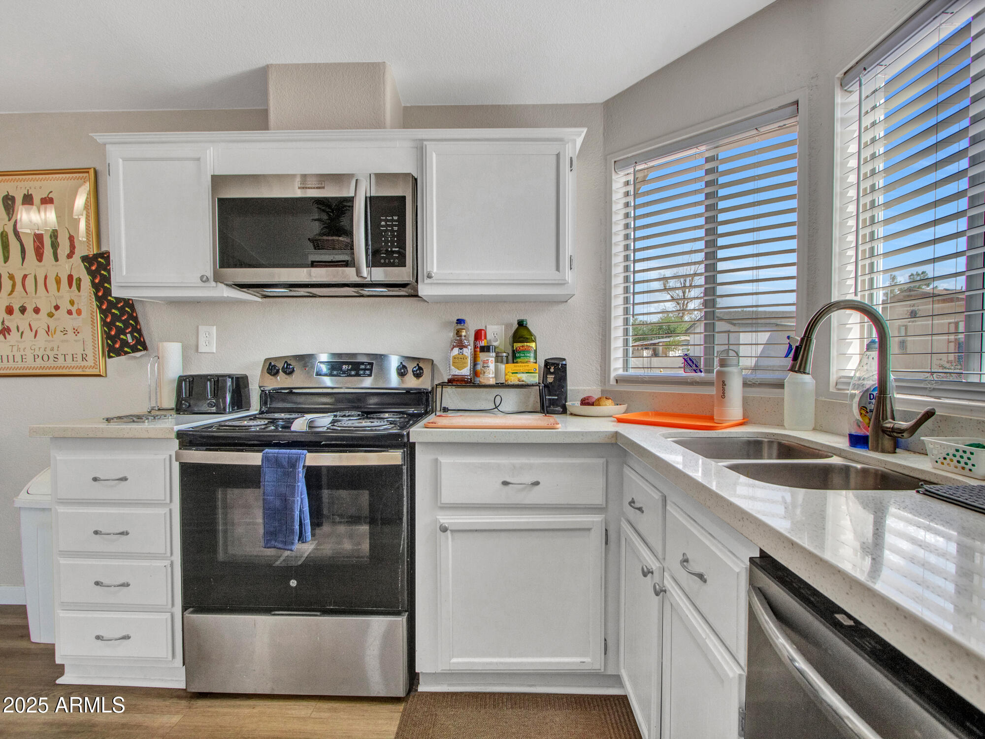 6227 North Litchfield Road, Unit 69 Litchfield Park, AZ 85340 - Photo 15 of 30 a kitchen with stainless steel appliances a stove a sink and a microwave
