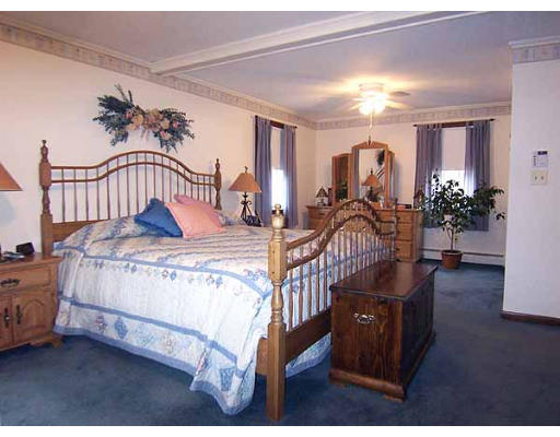 49 Dutchess Street Springfield, MA 01129 - Photo 12 of 25 a bedroom with a bed and a chandelier