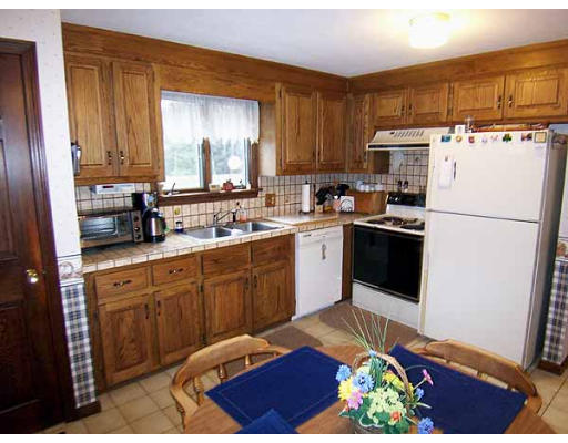 49 Dutchess Street Springfield, MA 01129 - Photo 3 of 25 a kitchen with stainless steel appliances granite countertop a refrigerator sink and wooden cabinets