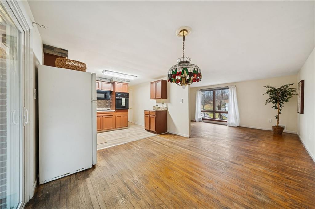 116 Grange Road Greensburg, PA 15601 - Photo 6 of 29 a view of a kitchen with a refrigerator a microwave and a wooden floor
