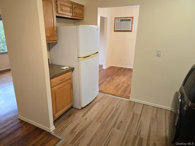 a view of a hallway with wooden floor and a sink
