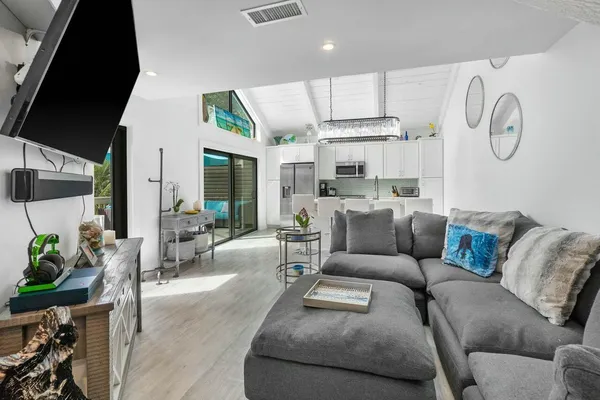 a living room with furniture a large window and potted plants