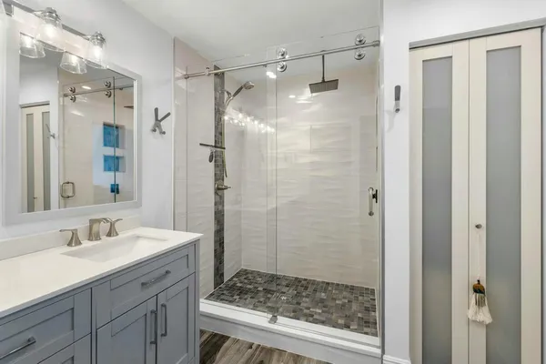 a bathroom with a shower sink and mirror
