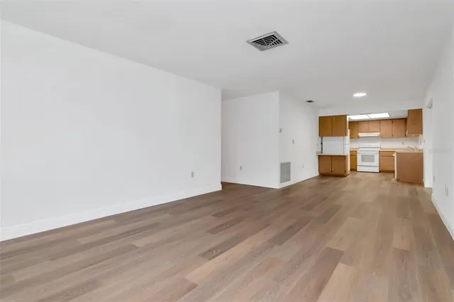 a view of empty room with wooden floor and windows