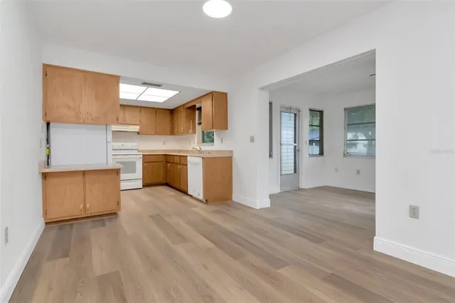 a view of a kitchen with wooden floor and electronic appliances