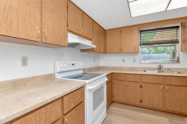 a kitchen with a sink cabinets and window