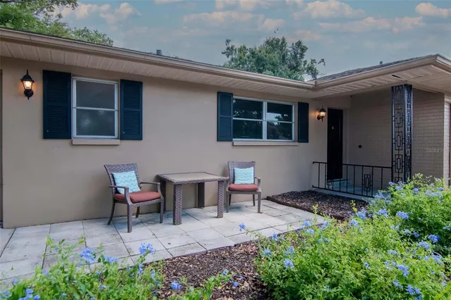 a view of a backyard with table and chairs and potted plants