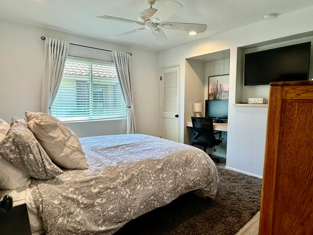 a bedroom with a bed and a flat screen tv