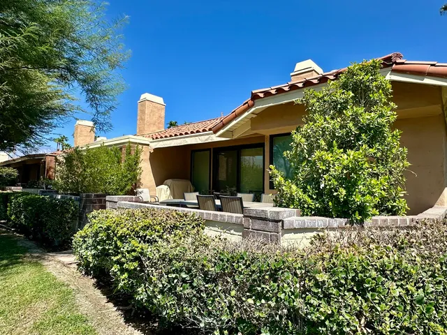 a view of a house with sitting area and garden
