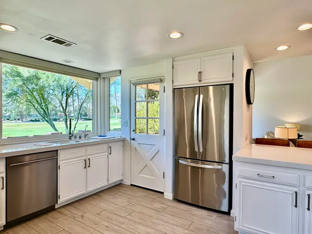 a kitchen with stainless steel appliances a refrigerator sink and cabinets