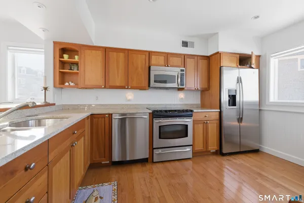 a kitchen with stainless steel appliances granite countertop a refrigerator sink and stove