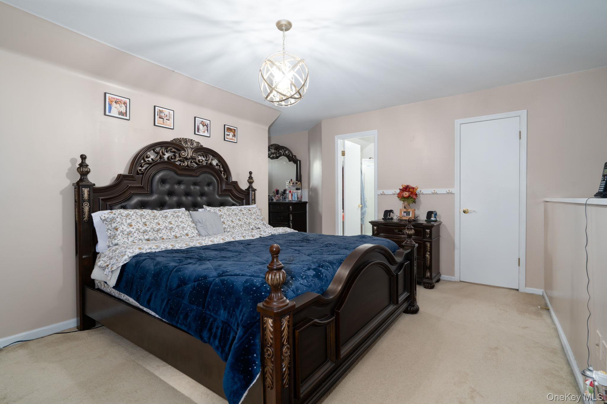 205 Ramapo Road, Unit H Garnerville, NY 10923 - Photo 19 of 31 a bedroom with a bed and a chandelier