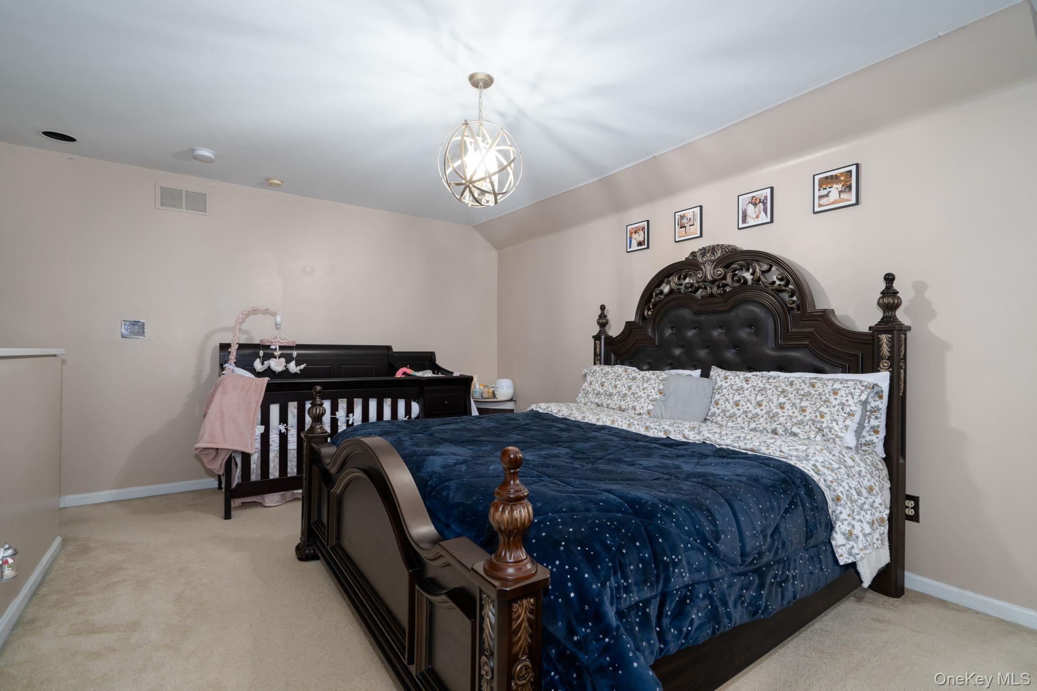 205 Ramapo Road, Unit H Garnerville, NY 10923 - Photo 20 of 31 a bedroom with a bed and a chandelier