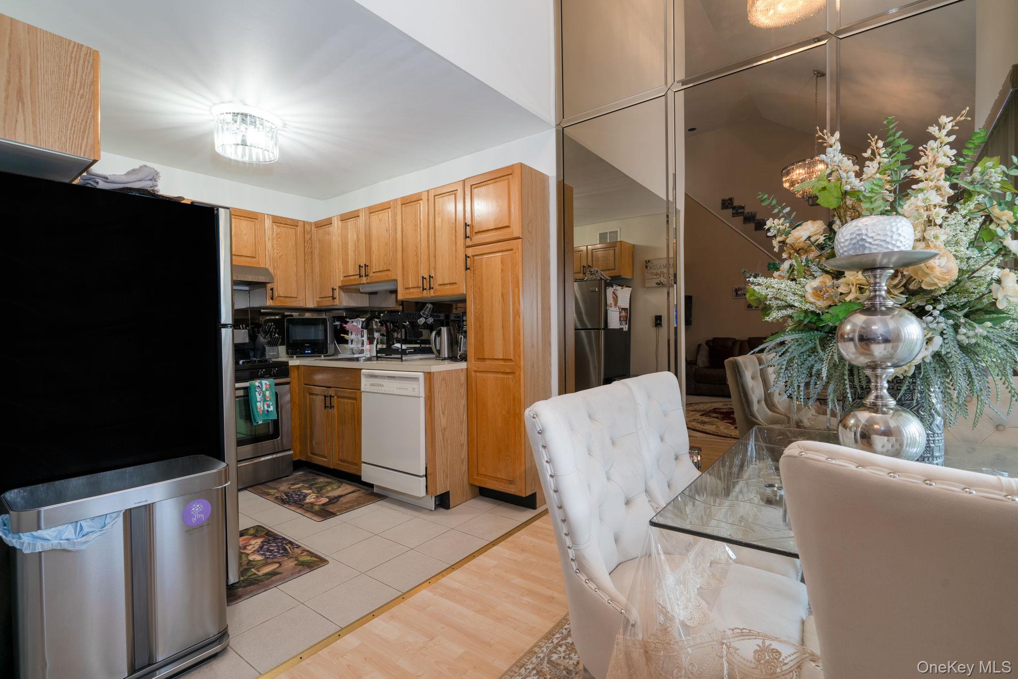 205 Ramapo Road, Unit H Garnerville, NY 10923 - Photo 6 of 31 a kitchen with stainless steel appliances kitchen island granite countertop a refrigerator a stove a sink dishwasher and white cabinets with wooden floor