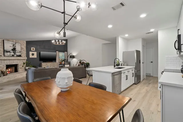 a kitchen with sink a refrigerator and chairs