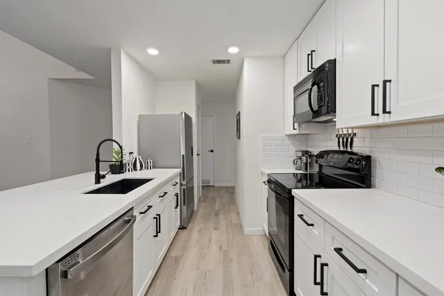 a kitchen with stainless steel appliances granite countertop a sink stove and refrigerator